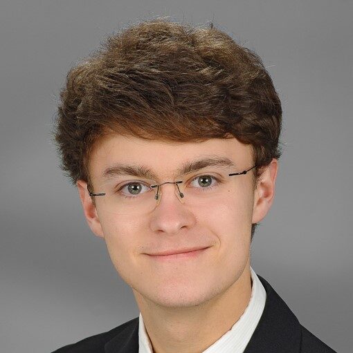 Mark Bruns grauer Hintergrund Anzug mit Krawatte